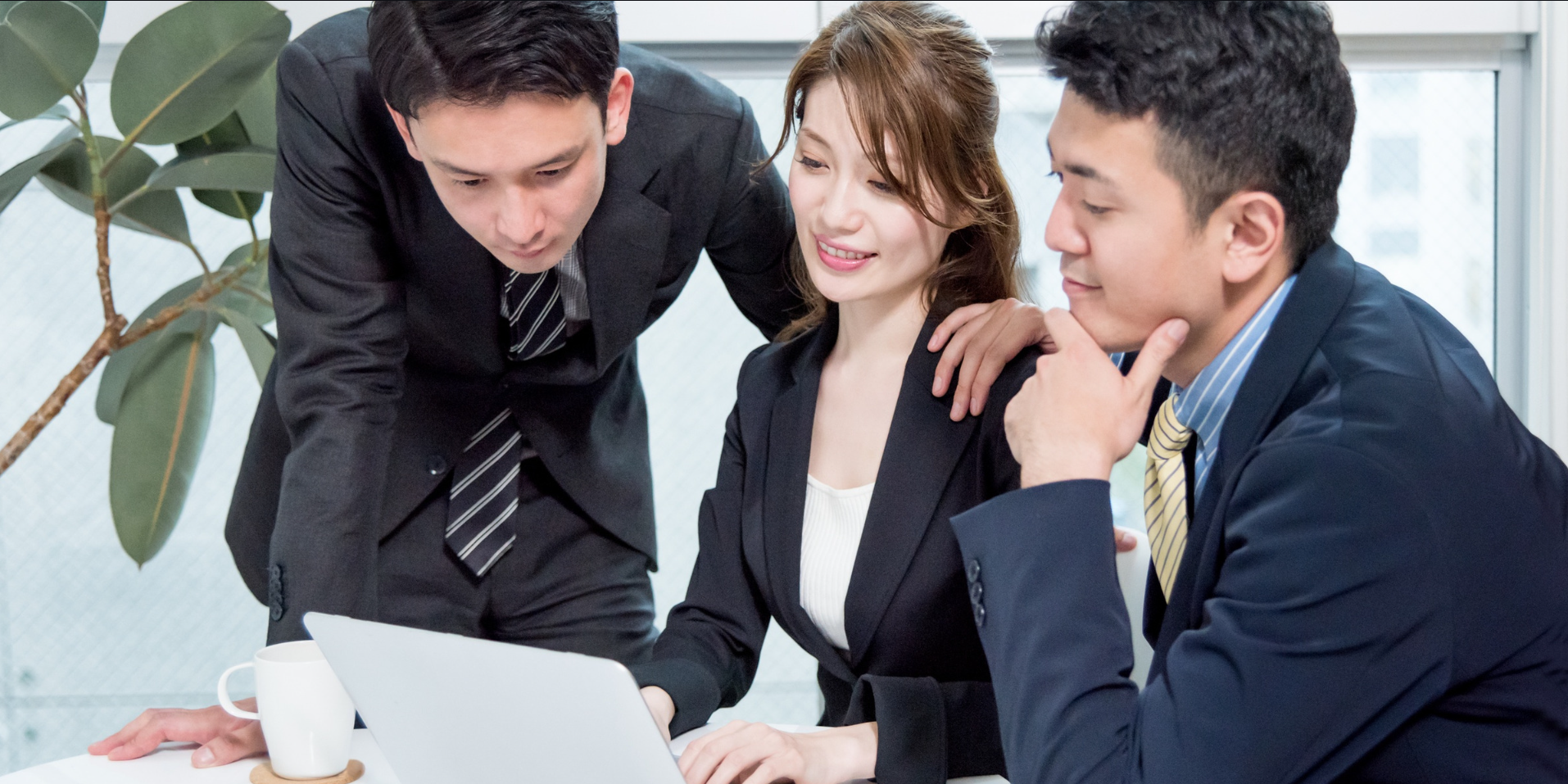 日本人3名がノートPCを囲んでマーケティングの打ち合わせをする様子